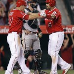 Los Angeles Angels' Mike Trout, left, celebrates with Albert Pujols after a two-run home run by Pujols, next to Arizona Diamondbacks catcher Jarrod Saltalamacchia during the sixth inning of a baseball game in Anaheim, Calif., Tuesday, June 16, 2015. (AP Photo/Alex Gallardo)
