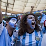 Soccer fans wearing the colors associated with Argentina's national soccer team, celebrate the opening goal scored against Belgium in a World Cup quarterfinals' match at the Estadio Nacional, in Brasilia, Brazil, Saturday, July 5, 2014. Gonzalo Higuain scored his first goal of this World Cup to give Argentina a 1-0 halftime lead over Belgium in their quarterfinal on Saturday. (AP Photo/Rodrigo Abd)