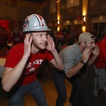 Ohio State fans Michael Hart, left, and Chris Davies, both of Columbus, Ohio, participate in quick calls with other fans during a party to watch the National Championship football game between Ohio State and Oregon on the campus of Ohio State University in Columbus, Ohio, Monday, Jan. 12, 2015. (AP Photo/Paul Vernon)