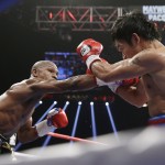 Floyd Mayweather Jr., left, drives Manny Pacquiao, from the Philippines, back with a right to the head during their welterweight title fight on Saturday, May 2, 2015 in Las Vegas. (AP Photo/Isaac Brekken)