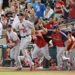 St. Louis Cardinals players including pitcher Adam Wainwright (50) and Matt Carpenter, right, run onto the field after the final out of a game between the St. Louis Cardinals and the Arizona Diamondbacks on Sunday, Sept. 28, 2014, at Chase Field in Phoenix, Ariz. The Cardinals clinched the National League Central Division championship and will face the Los Angeles Dodgers in the NLCS. (AP Photo/St. Louis Post-Dispatch, Chris Lee)