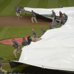 The grounds crew pulls a tarp over the field as a rain delay is called during the Opening day baseball game between the Pittsburgh Pirates and Cincinnati Reds Monday, April 6, 2015 in Cincinnati. (AP Photo/Michael E. Keating)