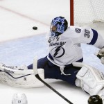 A puck slips wide of Tampa Bay Lightning goalie Ben Bishop during the second period in Game 6 of the NHL hockey Stanley Cup Final series against the Chicago Blackhawks on Monday, June 15, 2015, in Chicago. (AP Photo/Charles Rex Arbogast)