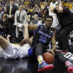 Buffalo's Xavier Ford (35) falls out of bounds after a collision with West Virginia's Nathan Adrian, left, in the first half of an NCAA tournament college basketball game in the Round of 64 in Columbus, Ohio Friday, March 20, 2015. (AP Photo/Paul Vernon)