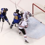 A shot by St. Louis Blues defenseman Barret Jackman (not shown) slides across the goal line behind Chicago Blackhawks goaltender Corey Crawford for the game-winning goal in overtime during Game 2 of a first-round NHL hockey playoff series on Saturday, April 19, 2014, in St. Louis. Blackhawks defenseman Nick Leddy, lower right, defends while Blues center Maxim Lapierre, left, and left wing Chris Porter apply pressure. (AP Photo/St. Louis Post-Dispatch, Chris Lee)