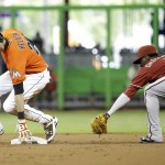 Miami Marlins' Christian Yelich, left, beats the throw to Arizona Diamondbacks shortstop Didi Gregorius, right, as he is safe with a double in the first inning during a baseball game, Sunday, Aug. 17, 2014, in Miami. (AP Photo/Lynne Sladky)