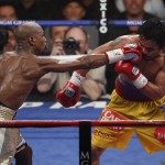 Floyd Mayweather Jr., left, hits Manny Pacquiao, from the Philippines, during their welterweight title fight on Saturday, May 2, 2015 in Las Vegas. (AP Photo/Eric Jamison)