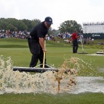 Course workers push rain water off the first hole during a weather delay in final round of the PGA Championship golf tournament at Valhalla Golf Club on Sunday, Aug. 10, 2014, in Louisville, Ky. (AP Photo/Mike Groll)