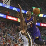 Phoenix Suns Eric Bledsoe, right, lays the ball in over Utah Jazz' Derrick Favors during the first half of an NBA basketball game in Salt Lake City, Saturday, Nov. 1, 2014. (AP Photo/George Frey)
