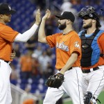 Miami Marlins right fielder Giancarlo Stanton (27), relief pitcher Chris Hatcher, center, and catcher Jarrod Saltalamacchia, right, celebrate after the Marlins defeated the Arizona Diamondbacks 10-3 in a baseball game, Sunday, Aug.17, 2014, in Miami. (AP Photo/Lynne Sladky)