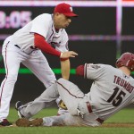 Washington Nationals second baseman Asdrubal Cabrera, left, tags out Arizona Diamondbacks' Mark Trumbo who was trying to steal second during the sixth inning of a baseball game on Thursday, Aug. 21, 2014, in Washington. The Nationals defeated the Diamondbacks 1-0. (AP Photo/Evan Vucci)