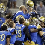 UCLA quarterback Jerry Neuheisel, top right, is carried off the field after UCLA's 20-17 win over Texas in an NCAA college football game, Saturday, Sept. 13, 2014, in Arlington, Texas. (AP Photo/Tony Gutierrez)