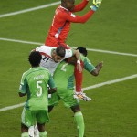 Nigeria's goalkeeper Vincent Enyeama, top, saves before Iran's Ashkan Dejagah, center in white, can head the ball during the group F World Cup soccer match between Iran and Nigeria at the Arena da Baixada in Curitiba, Brazil, Monday, June 16, 2014. The match ended in a goalless draw. (AP Photo/Michael Sohn)