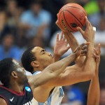 North Carolina forward Brice Johnson (with ball) is fouled by Harvard forward Steve Moundou-Missi during the first half of an NCAA tournament second round college basketball game Thursday, March 19, 2015, in Jacksonville, Fla. (AP Photo/Rick Wilson)