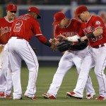 Los Angeles Angels shortstop Erick Aybar (2) celebrates with center fielder Mike Trout, second from right, and right fielder Kole Calhoun, right, with left fielder Daniel Robertson, left, watching after the Angels defeated the Arizona Diamondbacks 4-1 in a baseball game in Anaheim, Calif., Tuesday, June 16, 2015. (AP Photo/Alex Gallardo)
