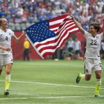 USA teammates Becky Sauerbrunn, left, and Meghan Klingenberg celebrate following their win over Japan at the FIFA Women's World Cup soccer championship in Vancouver, British Columbia, Canada, Sunday, July 5, 2015. (Jonathan Hayward/The Canadian Press via AP)