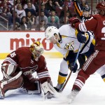 Arizona Coyotes' Louis Domingue (35) makes a save on a shot by Nashville Predators' Taylor Beck, middle, as Coyotes' Brandon Gormley (33) defends during the first period of an NHL hockey game Monday, March 9, 2015, in Glendale, Ariz. Gormley was called for a holding penalty on the play. (AP Photo/Ross D. Franklin)
