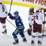 Vancouver Canucks center Henrik Sedin (33) celebrates teammate Yannick Weber's goal past Arizona Coyotes goalie Mike Smith (41) during the second period of an NHL hockey game Thursday, April 9, 2015, in Vancouver, British Columbia. (AP Photo/The Canadian Press, Jonathan Hayward)