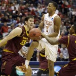  Texas' Demarcus Holland (2) is fouled by Arizona State's Jahii Carson (1) as Arizona State's Jordan Bachynski (13) watches during the first half of a second-round game in the NCAA college basketball tournament Thursday, March 20, 2014, in Milwaukee. (AP Photo/Jeffrey Phelps)