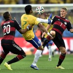 Brazil's Hulk is challenged by Germany's Jerome Boateng, left, and Bastian Schweinsteiger during the World Cup semifinal soccer match between Brazil and Germany at the Mineirao Stadium in Belo Horizonte, Brazil, Tuesday, July 8, 2014. (AP Photo/Martin Meissner)
