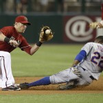 New York Mets' Eric Young Jr. (22) steals second base as Arizona Diamondbacks' Cliff Pennington, left, waits to catch the ball during the first inning of the MLB National League baseball game on Wednesday, April 16, 2014, in Phoenix. (AP Photo/Ross D. Franklin)
