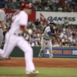 The Dodgers' third baseman Juan Uribe, right, throws out Diamondbacks' A.J. Pollock, center, during the Major League Baseball opening game between the Los Angeles Dodgers and Arizona Diamondbacks at the Sydney Cricket ground in Sydney, Saturday, March 22, 2014. (AP Photo/Rick Rycroft)