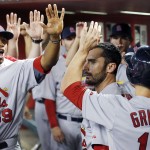 St. Louis Cardinals' Randal Grichuk, right, is greeted by teammates, including Xavier Scruggs (59) after Grichuk scored a run against the Arizona Diamondbacks during the third inning of a baseball game Saturday, Sept. 27, 2014, in Phoenix. (AP Photo/Ross D. Franklin)