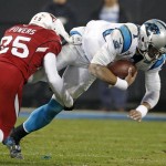 Carolina Panthers' Cam Newton, right, is tackled by Arizona Cardinals' Jerraud Powers, left, in the first half of an NFL wild card playoff football game in Charlotte, N.C., Saturday, Jan. 3, 2015. (AP Photo/Bob Leverone)