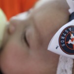 Five-month-old Melody Hernandez prepares for her very first baseball game between the Houston Astros and Cleveland Indians, Monday, April 6, 2015, in Houston. (AP Photo/Patric Schneider)