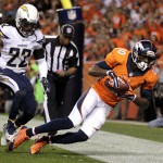 Denver Broncos wide receiver Emmanuel Sanders (10) scores a touchdown as San Diego Chargers cornerback Jason Verrett (22) defends during the first half of an NFL football game, Thursday, Oct. 23, 2014, in Denver. (AP Photo/Joe Mahoney)
