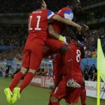 United States' Alejandro Bedoya, leaps onto teammates backs as helps celebrate after Clint Dempsey, No 8 at right, scored the opening goal during the group G World Cup soccer match between Ghana and the United States at the Arena das Dunas in Natal, Brazil, Monday, June 16, 2014. (AP Photo/Ricardo Mazalan)