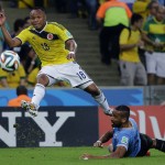 Colombia's Juan Zuniga, left, gets in a shot despite the challenge of Uruguay's Alvaro Pereira during the World Cup round of 16 soccer match between Colombia and Uruguay at the Maracana Stadium in Rio de Janeiro, Brazil, Saturday, June 28, 2014. (AP Photo/Sergei Grits)