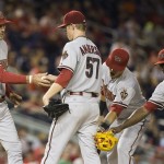 Arizona Diamondbacks manager Kirk Gibson, left, reaches for the ball after pulling pitcher Chase Anderson from the baseball game during the third inning against the Washington Nationals on Tuesday, Aug. 19, 2014, in Washington. From left are Gibson, Anderson, third baseman Jake Lamb, and shortstop Didi Gregorius. (AP Photo/Evan Vucci)