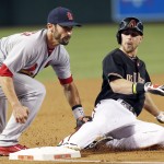 St. Louis Cardinals' Matt Carpenter, left, tags Arizona Diamondbacks' Ender Inciarte, right, out at third base as Inciarte tries to stretch a double into a triple during the first inning of a baseball game Saturday, Sept. 27, 2014, in Phoenix. (AP Photo/Ross D. Franklin)