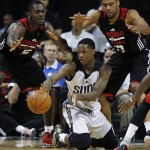 Phoenix Suns' Archie Goodwin, center, passes around Chicago Bulls' Bobby Portis, left, and Darrell Williams during the second half of an NBA summer league basketball game Saturday, July 18, 2015, in Las Vegas. (AP Photo/John Locher)
