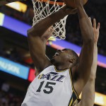 Utah Jazz' Derrick Favors, left, puts a shot up and over Phoenix Suns' Miles Plumlee during the second half of an NBA basketball game in Salt Lake City, Saturday, Nov. 1, 2014. The Jazz defeated the Suns 118-91. (AP Photo/George Frey)
