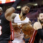 Phoenix Suns' Markieff Morris (11) pulls down a rebound between Miami Heat's Dwyane Wade (3) and Josh McRoberts, right, during the second half of an NBA basketball game Tuesday, Dec. 9, 2014, in Phoenix. The Heat defeated the Suns 103-97. (AP Photo/Ross D. Franklin)