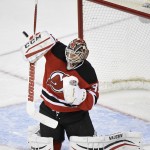 New Jersey Devils goaltender Cory Schneider deflects the puck during the second period of an NHL hockey game against the Arizona Coyotes Monday, Feb. 23, 2015, in Newark, N.J. (AP Photo/Bill Kostroun)
