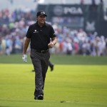 Phil Mickelson smiles as he walks down the fairway on the first hole during the final round of the PGA Championship golf tournament at Valhalla Golf Club on Sunday, Aug. 10, 2014, in Louisville, Ky. (AP Photo/John Locher)