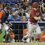 Arizona Diamondbacks' Cliff Pennington, right, watches after hitting a single in the sixth inning as Miami Marlins catcher Jarrod Saltalamacchia, left, looks on during a baseball game, Sunday, Aug. 17, 2014, in Miami. (AP Photo/Lynne Sladky)