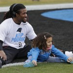 Carolina Panthers' DeAngelo Williams smiles as he stretches with his daughter Rhiya, 4, before an NFL wild-card playoff football game against the Arizona Cardinals in Charlotte, N.C., Saturday, Jan. 3, 2015. (AP Photo/Chuck Burton)