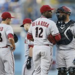Arizona Diamondbacks starting pitcher Rubby De La Rosa, second right, is visited at the mound by catcher Yasmani Grandal, right, while shortstop Nick Ahmed, left, and second baseman Chris Owings, rear second left, walk away during the first inning of a baseball game Monday, June 8, 2015, in Los Angeles. (AP Photo/Danny Moloshok)