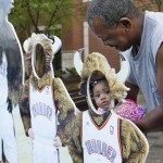 Anthony Rhone holds his grand-daughter Davaiana Williams, both of Oklahoma City, in a cut-out of the Oklahoma City Thunder mascot Rumble for her photo to be taken before the start of an opening-round NBA basketball playoff series between the Memphis Grizzlies and the Thunder in Oklahoma City, Monday, April 21, 2014. (AP Photo/Sue Ogrocki)
