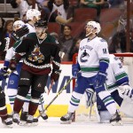 Arizona Coyotes' Tobias Rieder (8), of Germany, celebrates his goal against Vancouver Canucks' Eddie Lack (31) with teammate Mark Arcobello (36) as Canucks' Ryan Stanton (18) dejectedly skates near the celebration during the first period of an NHL hockey game Thursday, March 5, 2015, in Glendale, Ariz. (AP Photo/Ross D. Franklin)