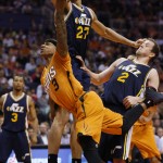 Phoenix Suns' Isaiah Thomas (3) shoots as Utah Jazz forward Joe Ingles (2) and Rudy Gobert (27) defend during the second half of an NBA basketball game, Friday, Feb. 6, 2015, in Phoenix. The Suns won 100-93. (AP Photo/Matt York)