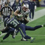 New England Patriots tight end Rob Gronkowski (87) is tackled by Seattle Seahawks strong safety Kam Chancellor (31) and outside linebacker K.J. Wright, rear, during the second half of NFL Super Bowl XLIX football game Sunday, Feb. 1, 2015, in Glendale, Ariz. (AP Photo/Elise Amendola)