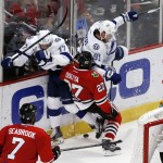 Chicago Blackhawks' Johnny Oduya (27), of Sweden, collides with Tampa Bay Lightning's Alex Killorn (17) and Steven Stamkos (91) during the second period in Game 6 of the NHL hockey Stanley Cup Final series on Monday, June 15, 2015, in Chicago. (AP Photo/Charles Rex Arbogast)