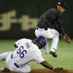 Japan's shortstop Kenta Imamiya throws to first dodging MLB All-Stars' Yasiel Puig's slide to second for a double play in the fifth inning of Game 4 of their exhibition baseball series at Tokyo Dome in Tokyo, Sunday, Nov. 16, 2014. (AP Photo/Koji Sasahara)