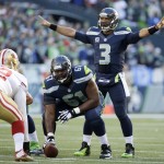 Seattle Seahawks quarterback Russell Wilson (3) calls to his team as he prepares to take a snap from center Lemuel Jeanpierre (61) in the first half of an NFL football game against the San Francisco 49ers, Sunday, Dec. 14, 2014, in Seattle. (AP Photo/Elaine Thompson)