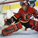Calgary Flames goalie Jonas Hiller, from Switzerland, reacts after letting in a goal by the Vancouver Canucks during second period NHL hockey action in Calgary, Alberta, Wednesday, Oct. 8, 2014. (AP Photo/The Canadian Press, Jeff McIntosh)